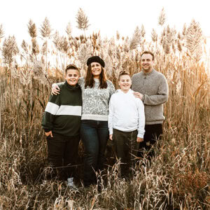 family in golden light in field of autumn pampass grass