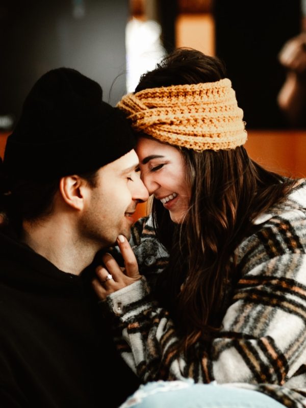 Newly engaged couple intimately snuggling in downtown St. Catharines, Ontario in front of the First Ontario Performing Arts Centre.