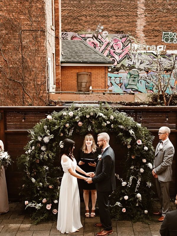 bride and groom holding hands during ceremony at the Spice Factory in downtown Hamilton