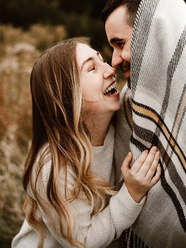 couple laughing in blanket at lake gibson in thorold