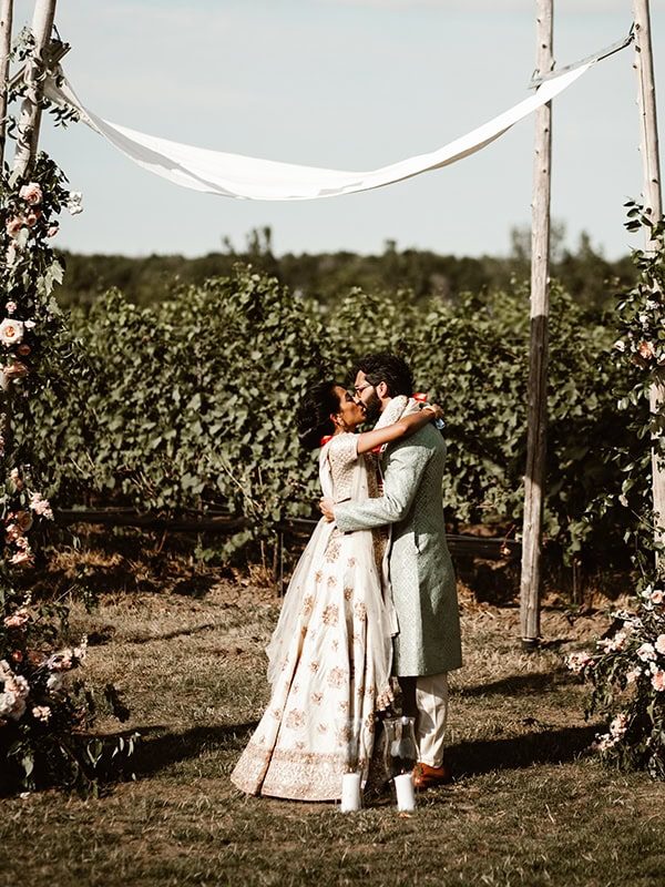 newly married couple kissing at Ravine Vineyard outdoor winery wedding